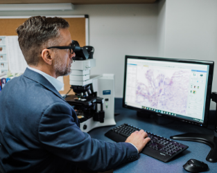 Dr. Winter examines through microscope
