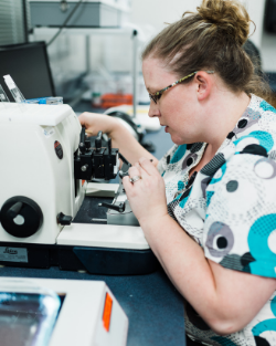 Histologist cutting surgical tissue on a microtome in pathology lab